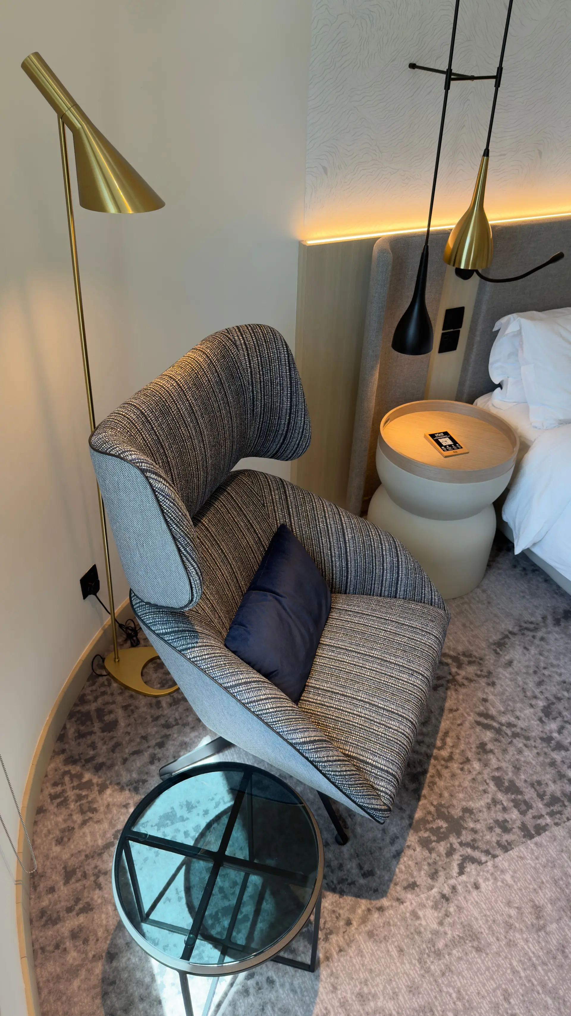 Luksuriøs lenestol og gyllen lampe i hotellsuite